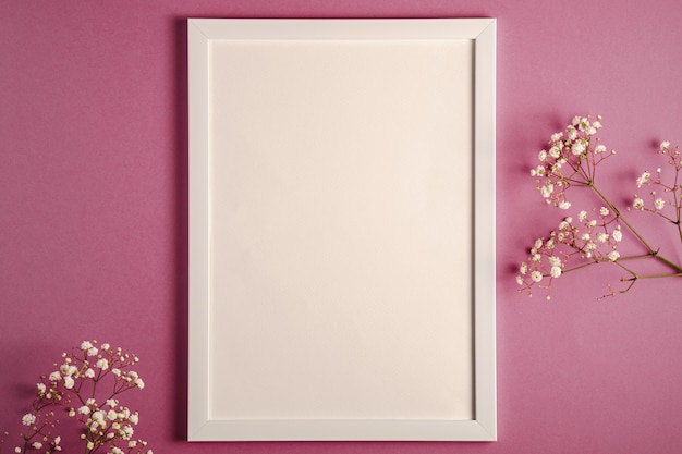 Photo white picture frame with empty template, gypsophila flowers, pink purple pastel background, mockup card