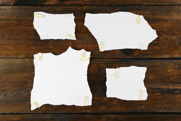 Photo white pieces of paper attached on wooden background