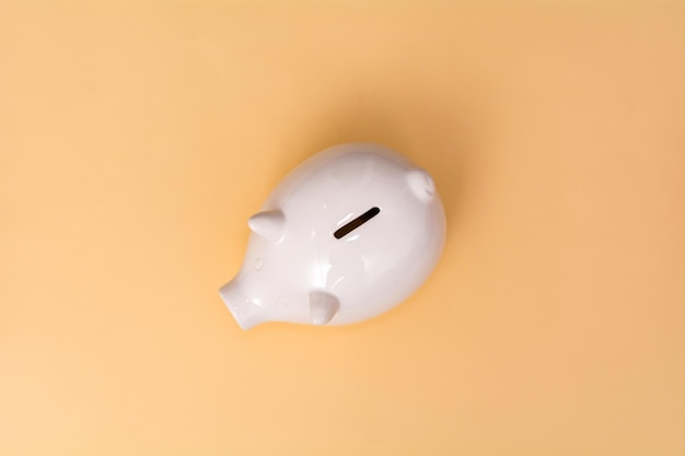 White pig piggy bank on a beige background View from above