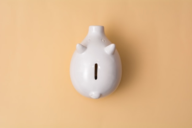 White pig piggy bank on a beige background