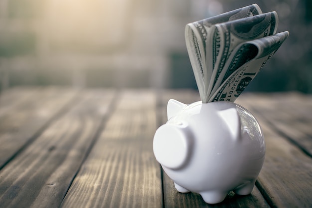 White piggy bank and coin on wood,Concept save money