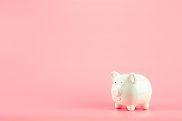 White piggy bank on pink background. - save and management concept.