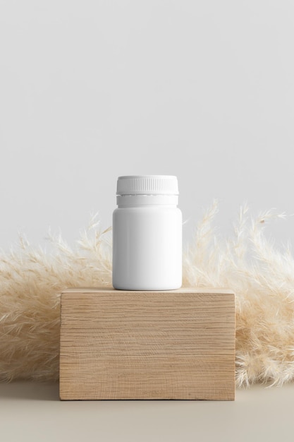 White pill bottle mockup with a pampas decoration