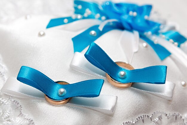 파란색 리본이 있는 결혼 반지용 흰색 베개