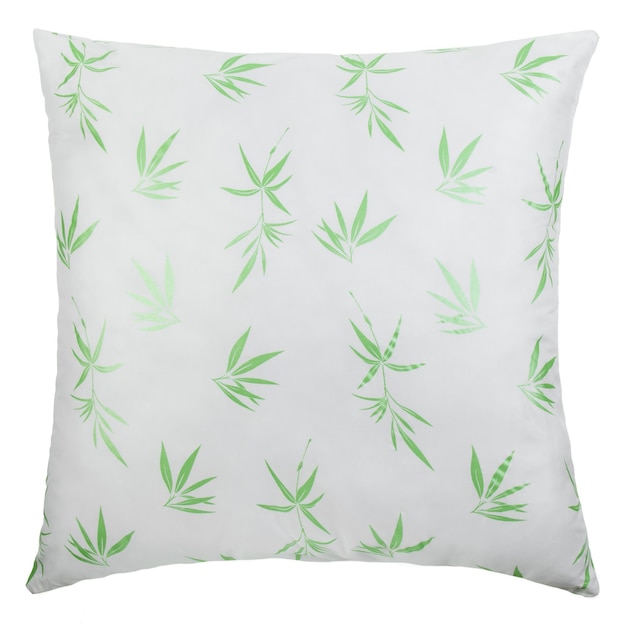 A white pillow with a green leaf pattern on it.