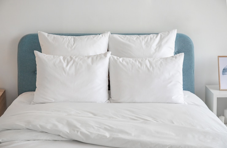 Photo white pillows and duvet on the blue bed.