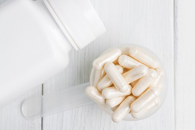 White pills or capsules in a plastic spoon, medication treatment, alternative medicine, close-up, top view