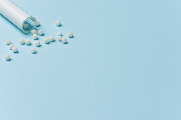 White pills spilled on a blue background