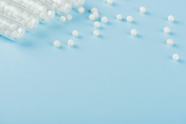 Pillole bianche versate su uno sfondo blu