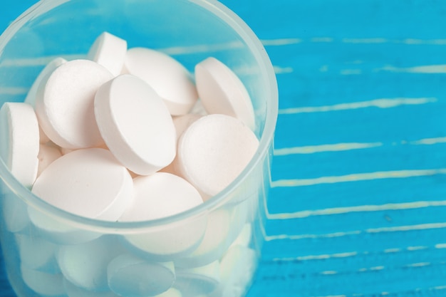 White pills spilled out of a white container