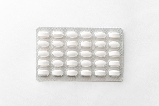 White pills tablets in package on a white