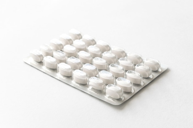 White pills tablets in package on a white