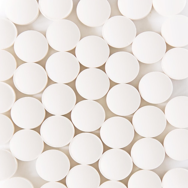 White pills on a white background round pills closeup Healthcare and medicine