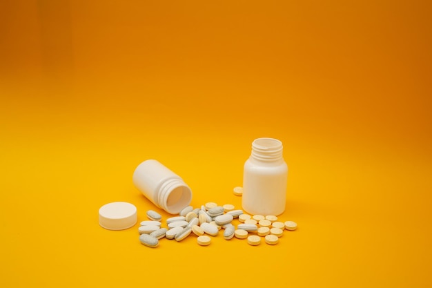 White pills on a yellow background medical theme