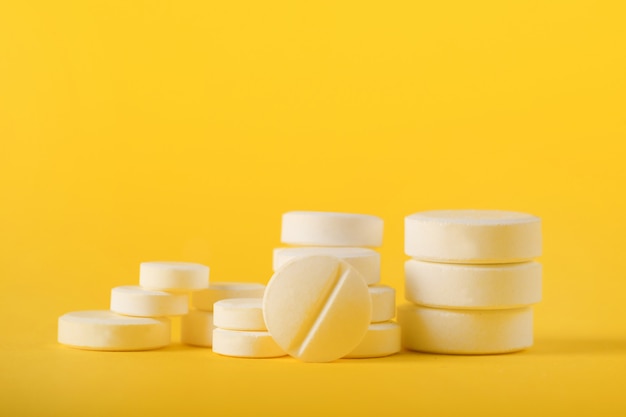 White pills on yellow background