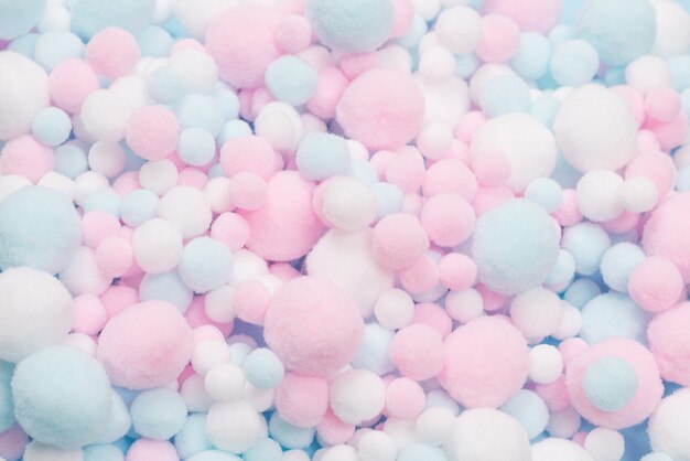 White, pink and blue soft pompons as a background. Bright background.