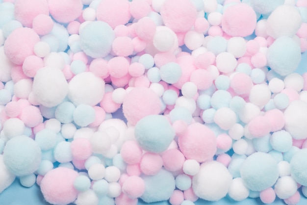 White, pink and blue soft pompons as a background. Bright background.