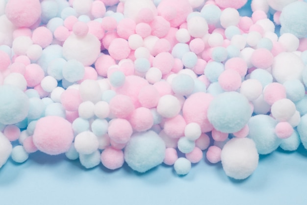 White, pink and blue soft pompons as a background. Bright background.
