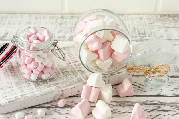 White and pink marshmallows for roasting and hot chocolate in a\
bowls, close up. winter food background concept.
