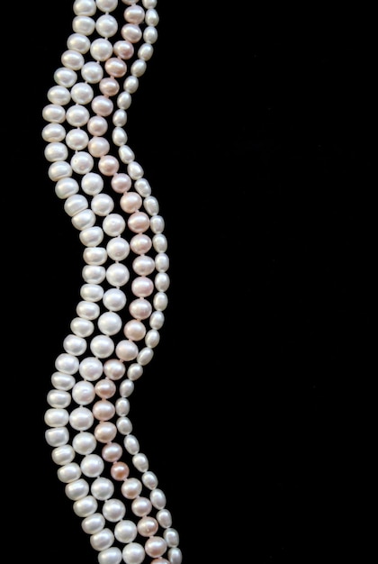 Photo white and pink pearls on the black silk