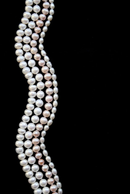 White and pink pearls on the black silk