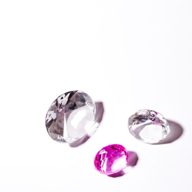 White and pink transparent diamonds on white background