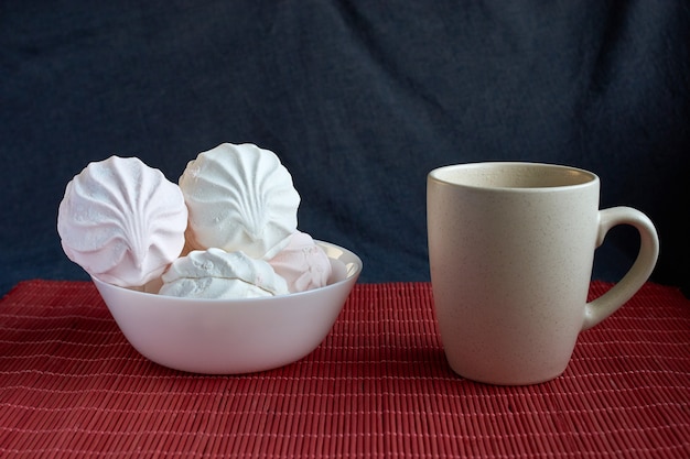 Photo white and pink zephyr marshmallow with cap of tee on porcelain plate