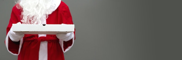 흰 장갑에 산타 클로스의 손에 흰색 피자 상자.