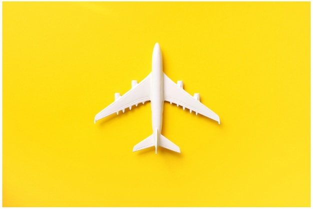 White plane, airplane on yellow color background with copy space. 