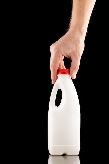 White plastic bottle in hand