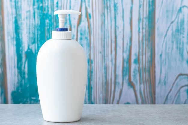 White plastic bottle of lotion, soap with dispenser. Toiletry in bathroom. Empty place. Hygiene concept.