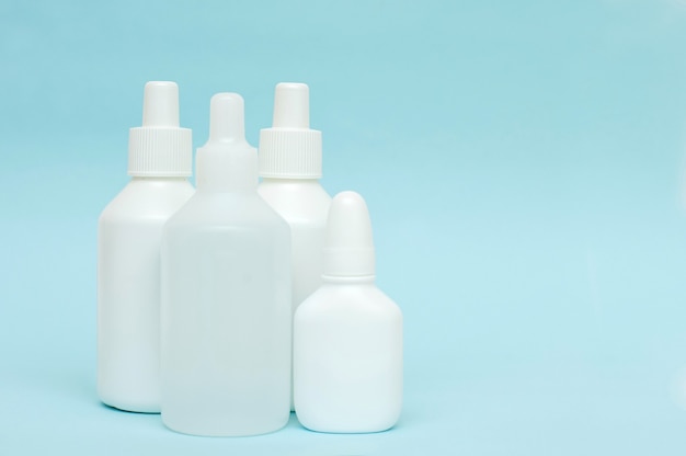 White plastic bottles of medicines on a blue background.