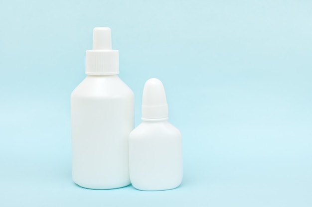 White plastic bottles of medicines on a blue background.