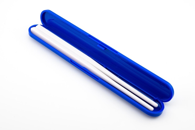Белые пластиковые палочки в синем контейнере для суши
