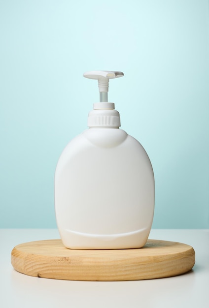 white plastic container with a pump for cosmetic liquid liquid soap on the table