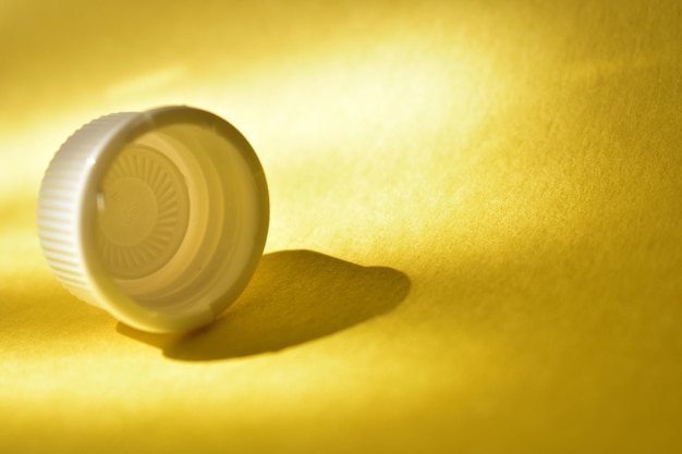 A white plastic cup on a yellow background