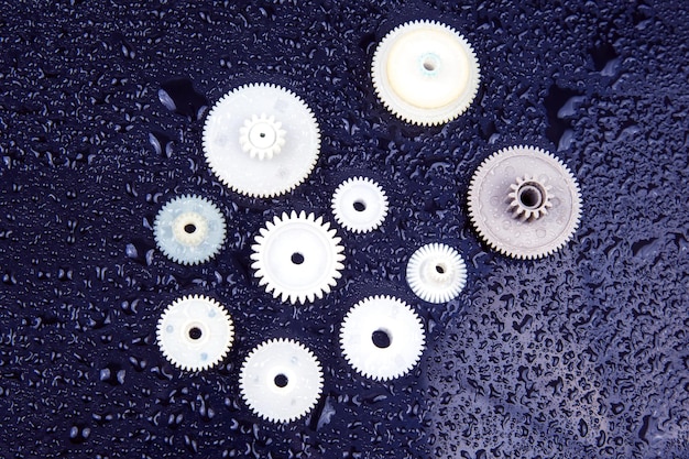 White plastic gears on a dark background connection mechanism\
details subject of movement