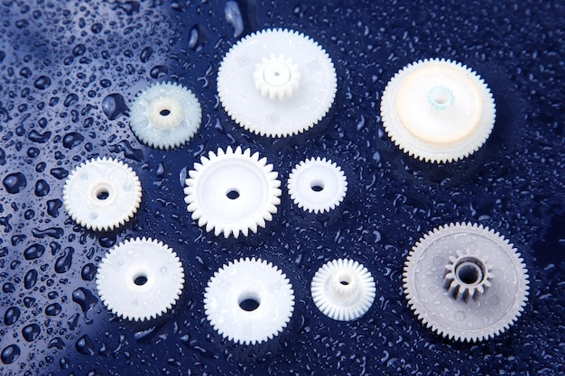 White plastic gears on a dark background connection mechanism details subject of movement