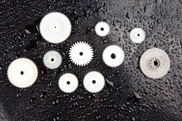 White plastic gears on a dark background connection mechanism\
details subject of movement