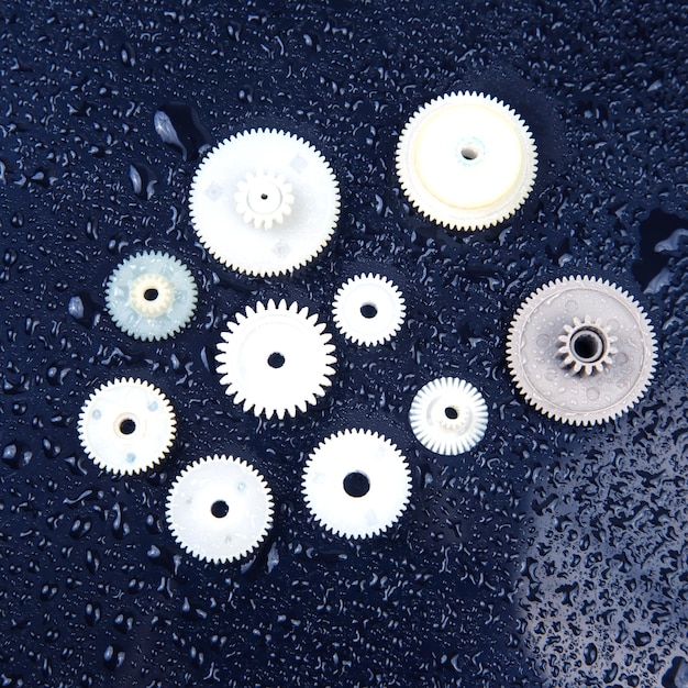 White plastic gears on a dark background connection mechanism details subject of movement