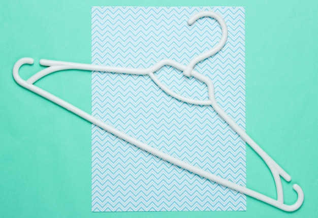 Photo white plastic hanger on blue paper