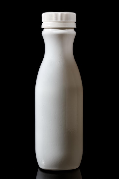 White plastic milk bottle isolated on black