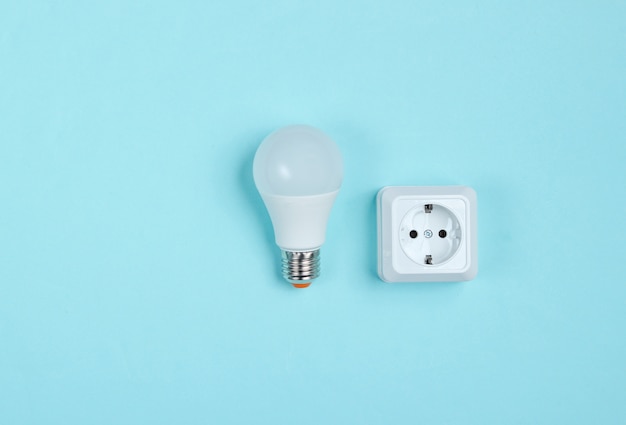 White plastic power socket and LED light bulb. Minimalism. Top view