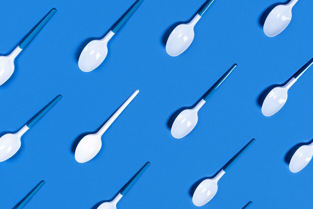 Photo white plastic spoons on blue.