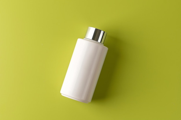 White plastic tube or jar mock up on light green background Copy space flat lay top view Concept