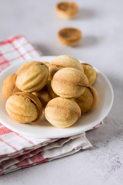 White Plate Cookies Nuts with Condensed Milk Gray Background Vertical