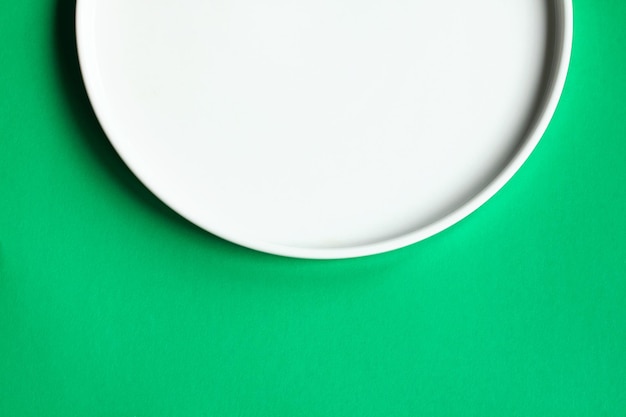 White plate on a green background top view