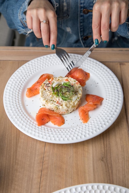 White plate and Smoked fish with Risotto Dish meal and women hand Leaf vegetable salad