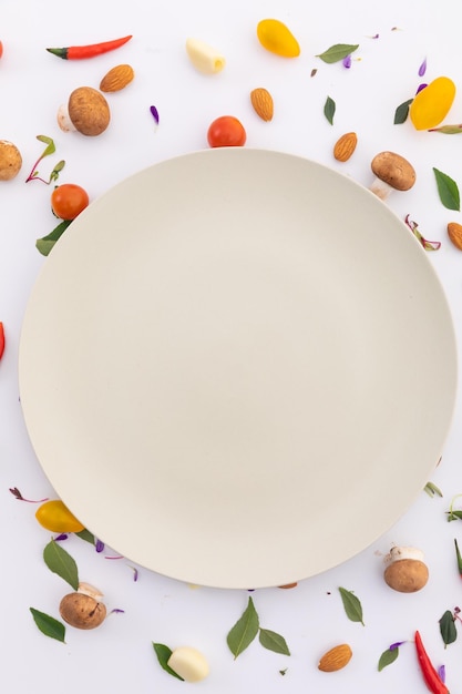 White plate surrounded by fresh vegetables on white background. fresh produce green vegetables healthy eating organic food preparation concept.