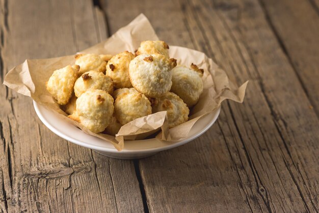 White Plate of Sweet Coconut Cookies on Old Wooden Background Horizontal Copy Space